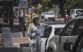 A health professional conducts a COVID-19 coronavirus test at a drive through testing site outside the Lancet Laboratories facilities in Johannesburg.