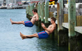 Sam Dickson, left, and Scott Curry synchronise dive into Wellington Harbor after training.