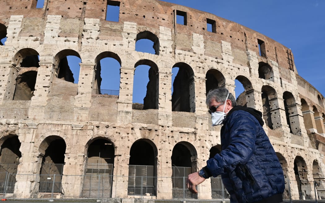 A man wearing a respiratory mask  walks past the closed Colosseum  in Rome on 10 March, 2020