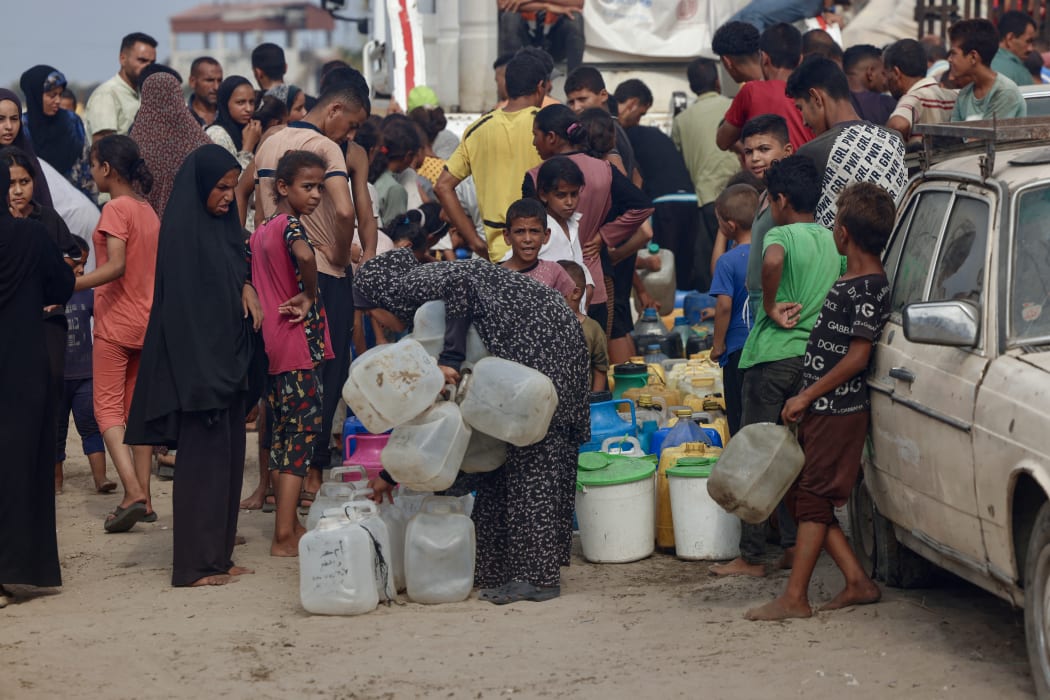 Palestinians queue to fill up on drinking water in the sweltering heat in the Mawasi area of Khan Yunis in the southern Gaza Strip on 12 August, 2025.
