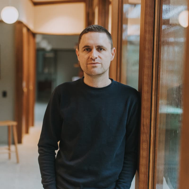 Christian White wears a long-sleeved black t-shirt and has short dark hair.