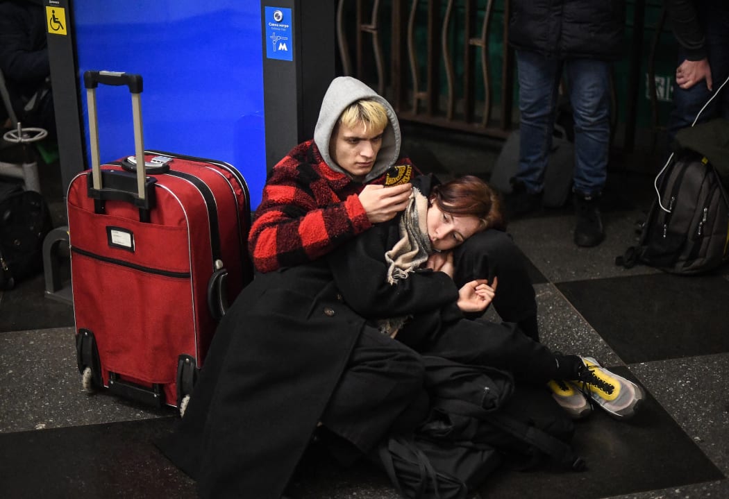 People use their phone as they take shelter in a metro station in Kyiv as air raid sirens rang out.