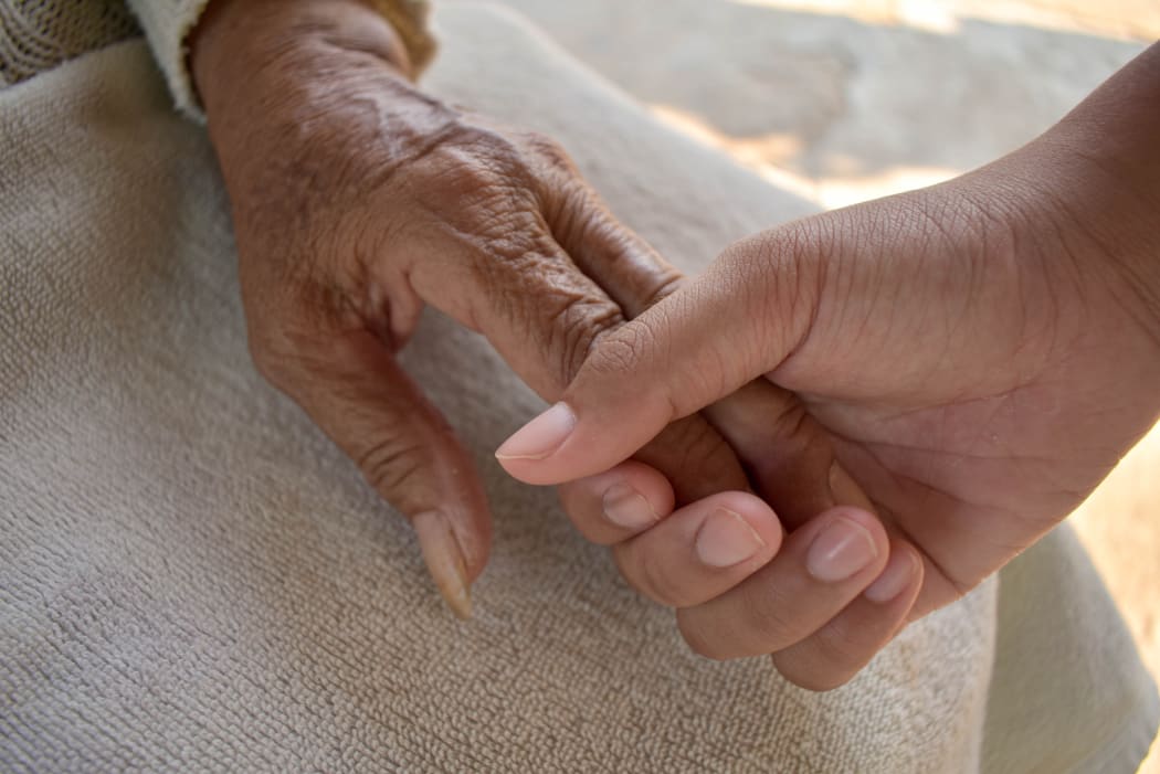 Close up granddaughter takes care of the health sick grandmother at home by holding hands. Lifestyle support the love of the family.