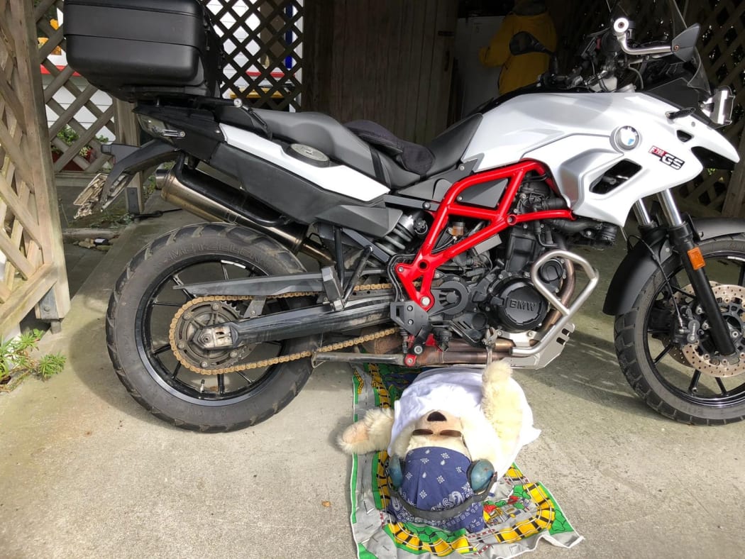 Chester the bear fixes a motorcycle.