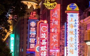 Neon signs on city street (Photo by Ben Pipe Photography / Cultura Creative / Cultura Creative via AFP)