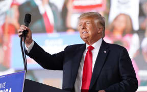 PERRY, GA - SEPTEMBER 25: Former US President Donald Trump adjusts the microphone at a rally on September 25, 2021 in Perry, Georgia.
