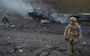 Ukrainian service members look for unexploded shells after a fighting with Russian raiding group in the Ukrainian capital of Kyiv in the morning of February 26, 2022.