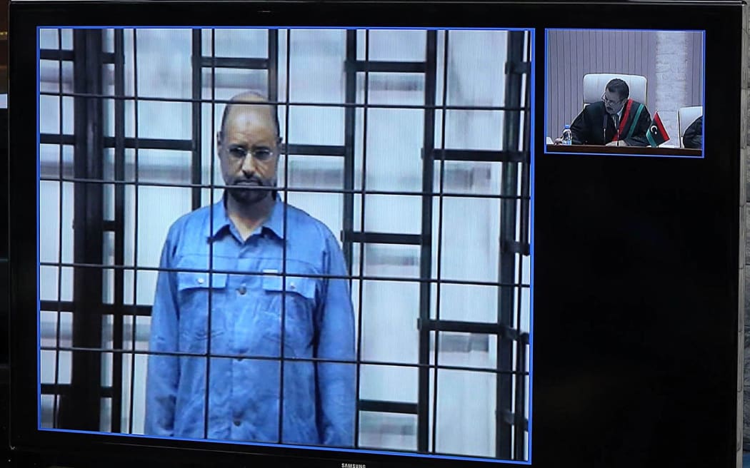 Saif Al-Islam Gaddafi during his trial, with the judge to the right.