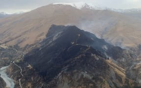 Fire and Emergency New Zealand crew discusses the plan for managing the Skippers Canyon fire today.