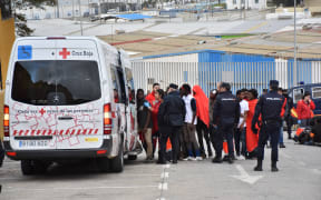 Migrants queue to board a Red Cross bus in El Tarajal, Ceuta, close to the border with Morocco on 9 December, 2016 after being rounded up by police.