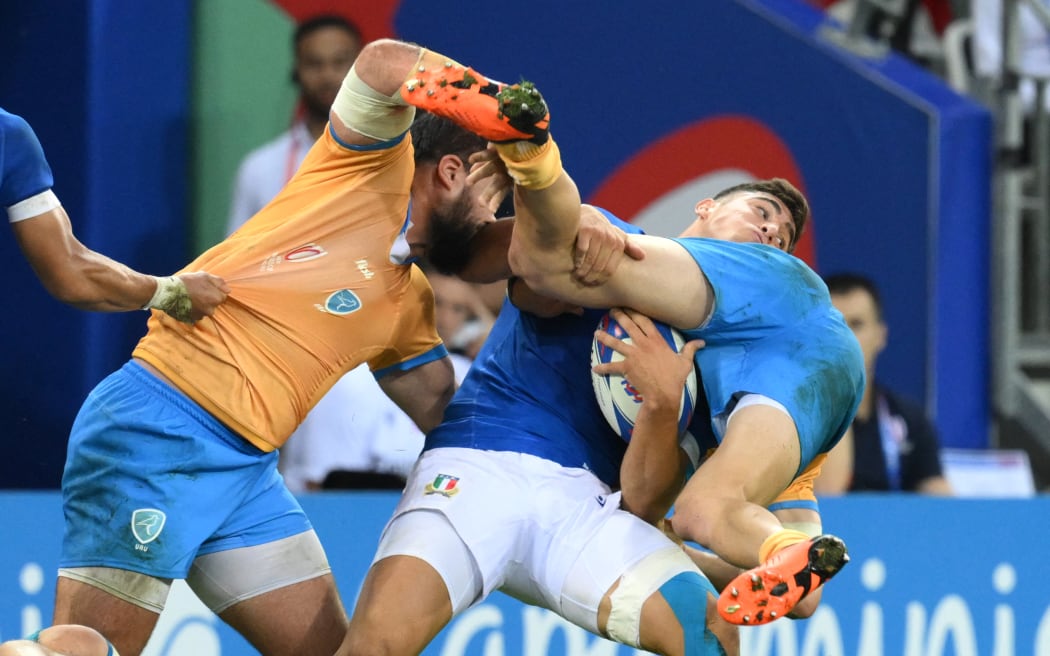 Italy's scrum-half Alessandro Fusco is tackled by two Uruguay players during the France 2023 Rugby World Cup