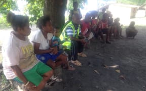 Vanuatu Emergency Medical Team's Dr Andy Ilo, (in vest) speaking with Ambae evacuee leaders.