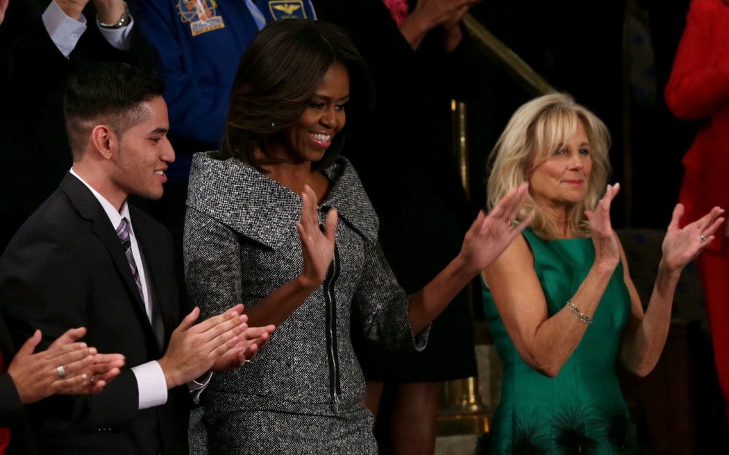 First lady Michelle Obama, alongside Dr Jill Biden (R), waves after arriving for US President Barack Obama's State of the Union speech.