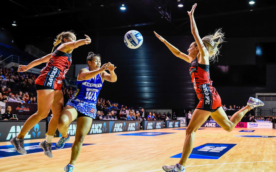 Elisapeta Toeava of the Mystics passes the ball underpressure from Charlotte Elley and Jane Watson of the Tactix.