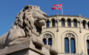 symbolic lion and norwegian flag at oslo parliament building