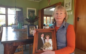 Heather Gregory, with a wedding photo showing her late husband Richard.