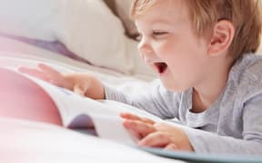 boy reading and smiling