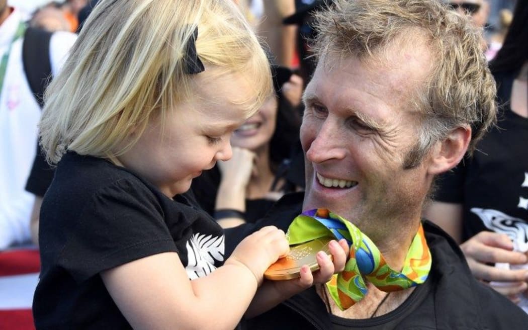 Mahe Drysdale and his daughter Bronte admire his gold medal after winning the men's single sculls.