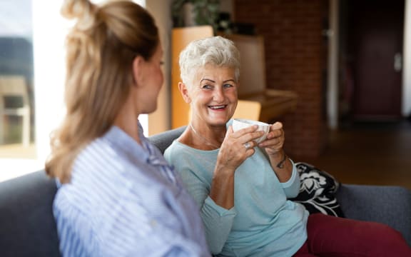 Two women chatting over a cup of tea.