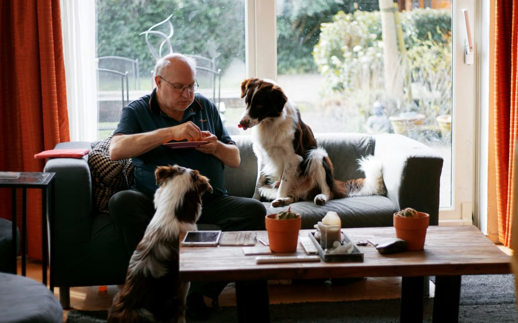 A man and his two devoted dogs awaiting some treats