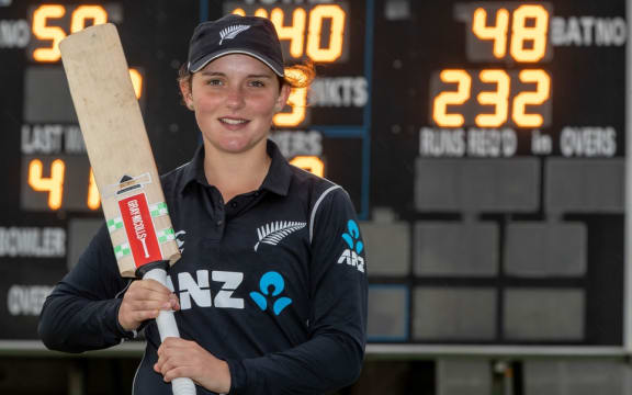 Amelia Kerr in front the scoreboard showing her record score.