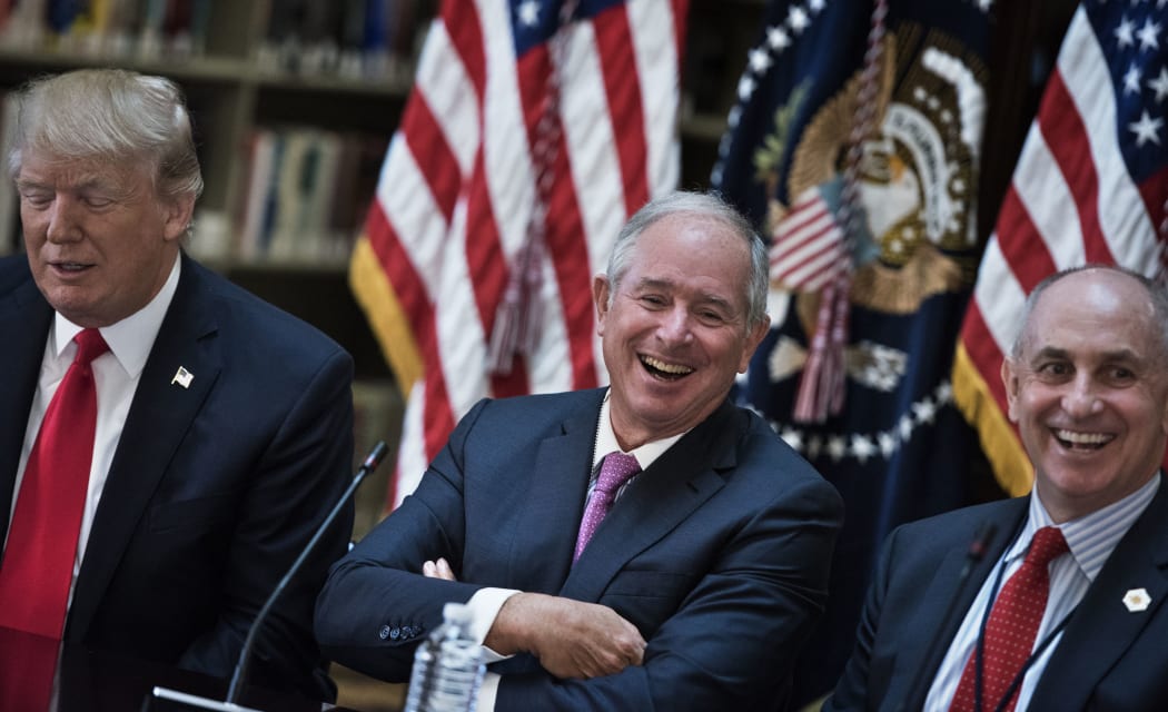 Stephen A. Schwarzman (C), CEO of the Blackstone Group, and Chris Liddell (R), White House Director of Strategic Initiatives, and US President Donald Trump (L) and others in the  White House campus April 11, 2017 in Washington, DC.