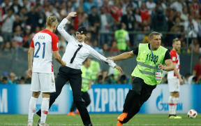 Stewards remove pitch invaders during the Russia 2018 World Cup final football match between France and Croatia at the Luzhniki Stadium in Moscow on July 15, 2018