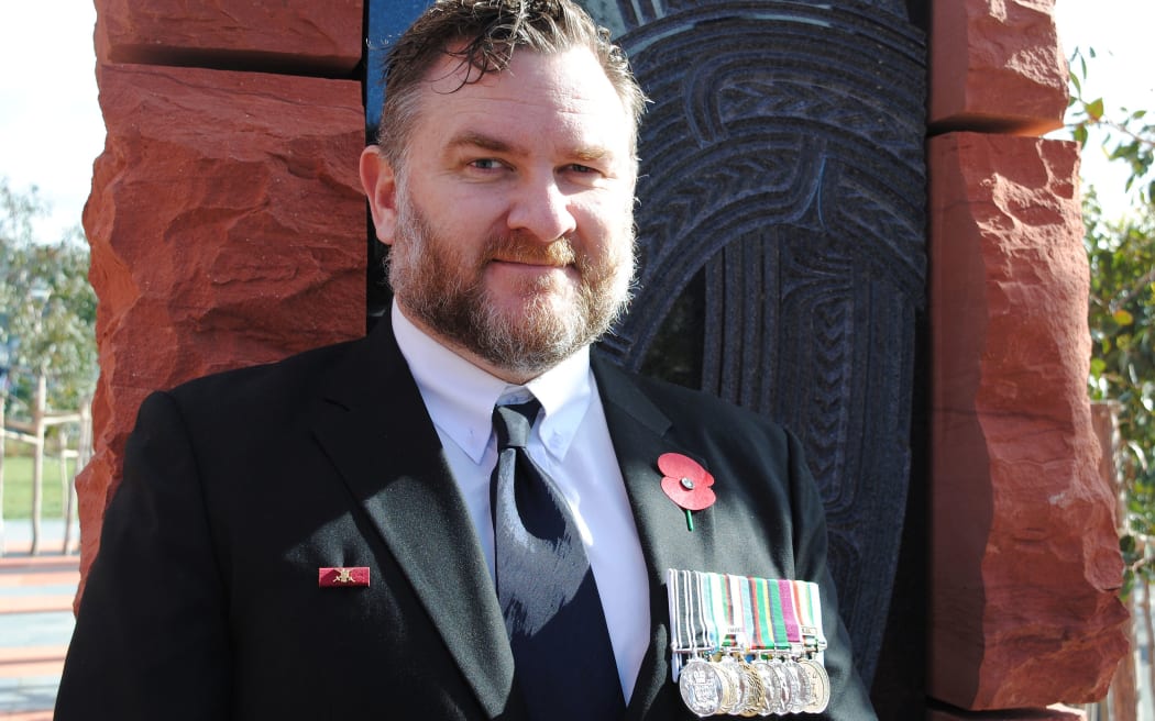 Ex solider wearing a suit and medals at commemoration service