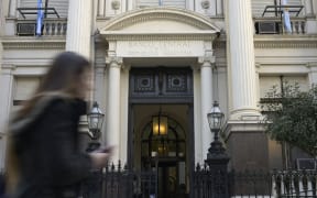 A woman passes by the headquarters of Argentina's Central Bank in the financial district of Buenos Aires