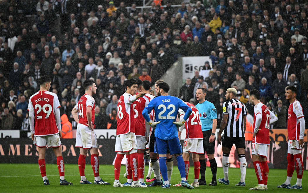 Referee Stuart Attwell and players wait as the VAR looks at the reasons for allowing or not, the opening goal.