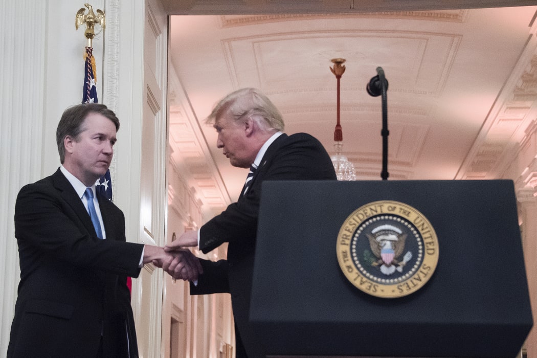 US President Donald Trump shakes hands with Associate Justice of the US Supreme Court Brett Kavanaugh on the back during a ceremonial swear-in at the White House
