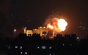 Smoke and fire rise following Israeli air strikes on a building in Gaza City late on 5 August, 2022.