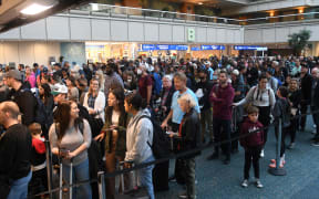 People wait in a TSA checkpoint line at Orlando International Airport.
