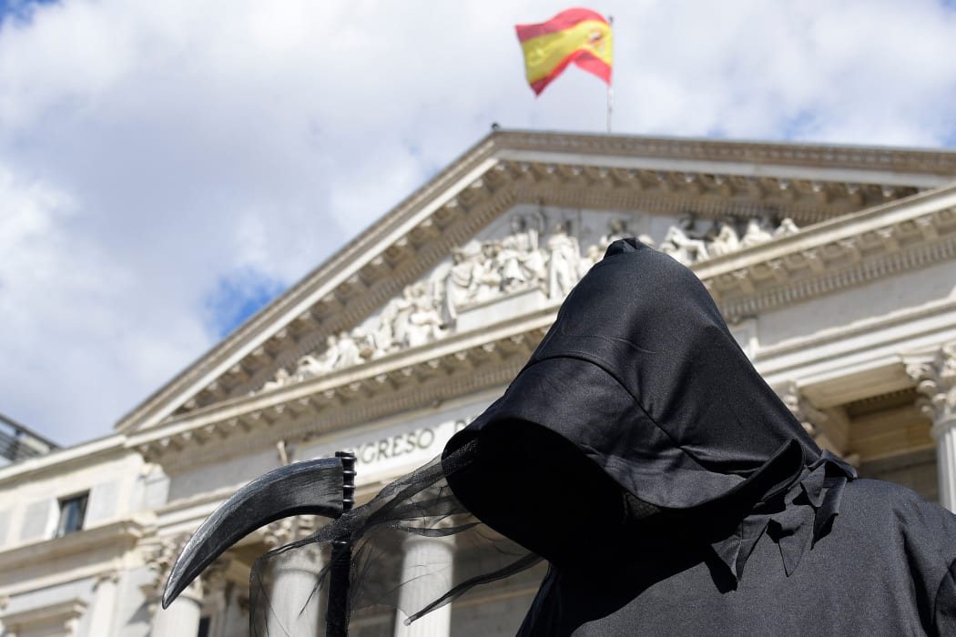 A protester dressed as Death demonstrates against a law legalising euthanasia in Madrid on March 18, 2021 as Parliament gives final approval to bill decriminalising euthanasia and physician-assisted suicide.