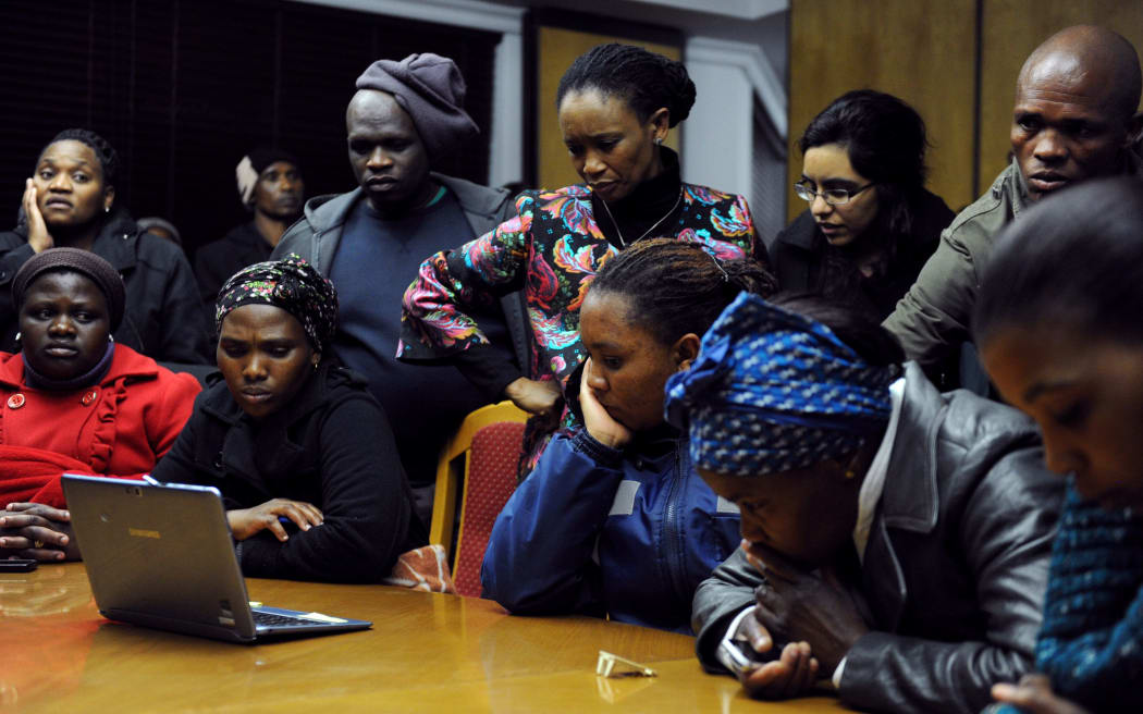 Relatives of miners killed during the Marikana police shooting listen President Jacob Zuma delivering the findings of a commission of inquiry.