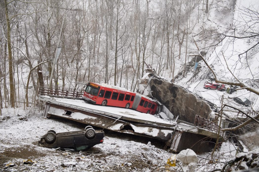 Vehicles including a Port Authority bus are left stranded after a bridge collapsed along Forbes Avenue in Pittsburgh, Pennsylvania on 28 January, 2022.