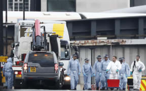 The white van used in the attack on London Bridge is hoisted on top of a flat-bed truck as police work on gathering evidence and securing the area.