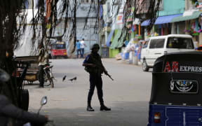 A Sri Lankan naval soldier stands guard at a road leading to a closed market on May Day in Colombo, Sri Lanka, Wednesday, May 1, 2019.
