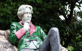 Dublin, Ireland August 17, 2018: Sculpture of writer Oscar Wilde in Merrion Square. The artwork by Danny Osborne was unveiled in 1997. The art shows Wilde reclining on a large boulder.