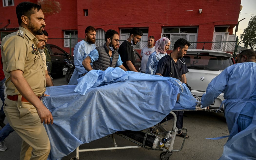 Paramedics and police personnel carry an injured tourist at a hospital in Anantnag, south of Srinagar, on April 22, 2025, following an attack. Gunmen in Indian-administered Kashmir opened fire on a group of tourists on April 22, with the chief minister saying the "inhuman" attack was one of the worst targeting civilians for years. At least five people were killed, a senior politician in the Himalayan region said. (Photo by Tauseef MUSTAFA / AFP)