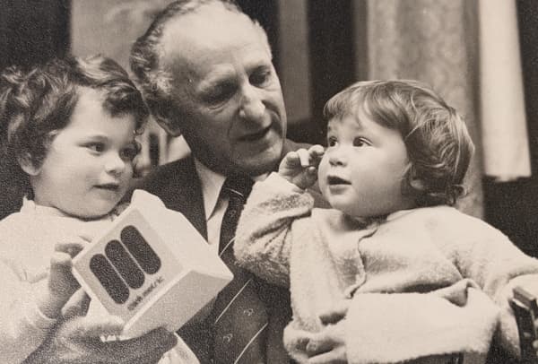 Jeannie and her brother with an unnamed politician. The block he's holding carries the logo of the Metric Advisory Board.