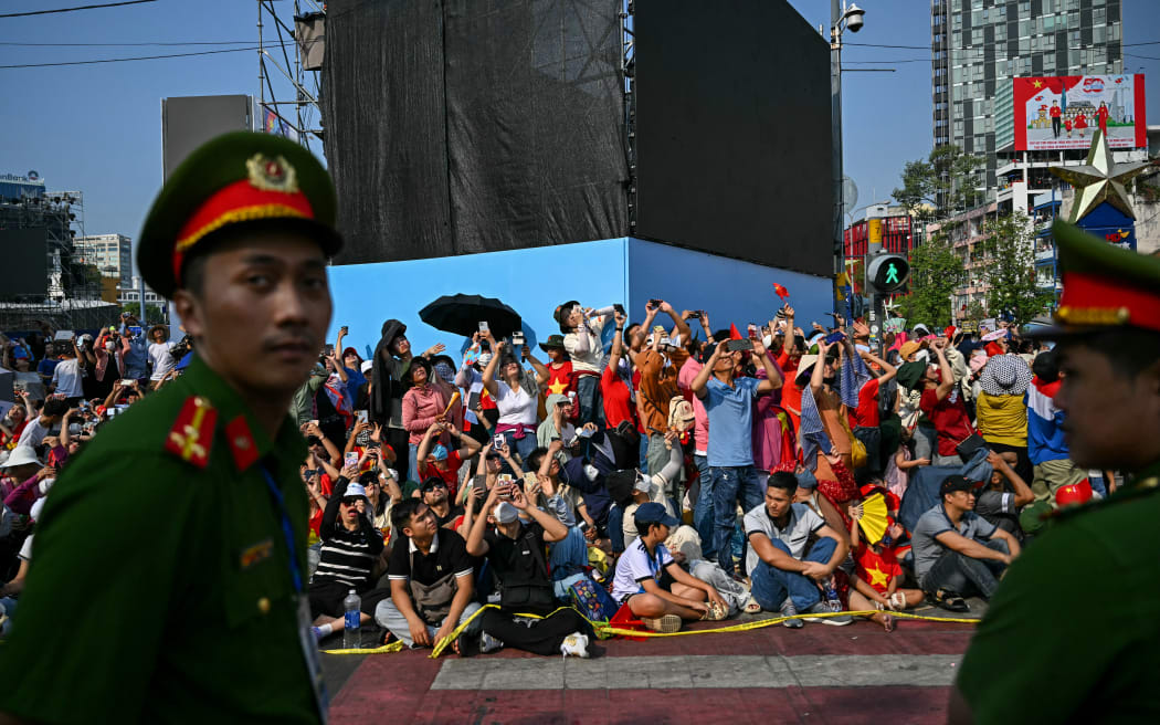 Spectators watch an airshow during celebrations marking the 50th anniversary of the fall of Saigon and the end of the Vietnam War in Ho Chi Minh City on April 30, 2025. Vietnam held its biggest celebration of the fall of Saigon on its 50th anniversary on April 30, including Chinese troops for the first time after Xi Jinping visited to portray Beijing as a more reliable partner than Washington. (Photo by Manan VATSYAYANA / AFP)