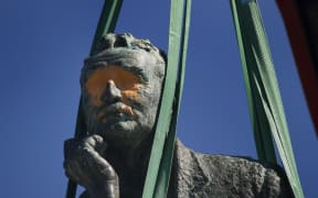 The defaced statue being removed