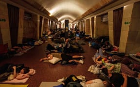 People sleep on the platform of a metro station in Kyiv, as they take cover during a Russian attack.