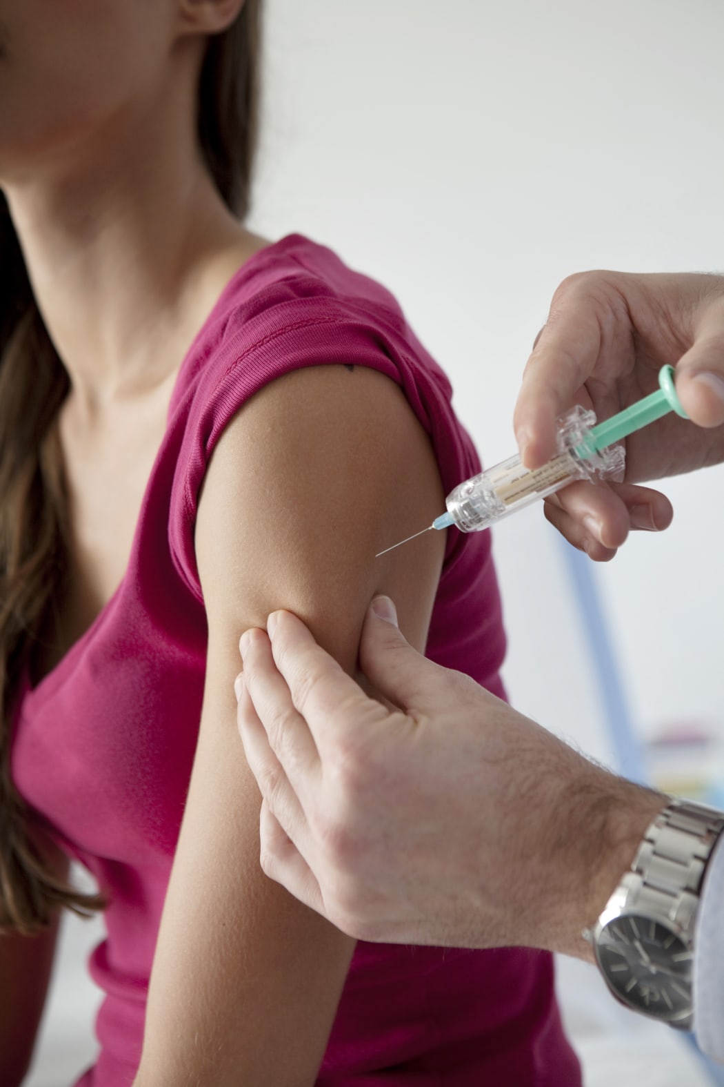 A young woman receives a dose of HPV vaccine Gardasil.