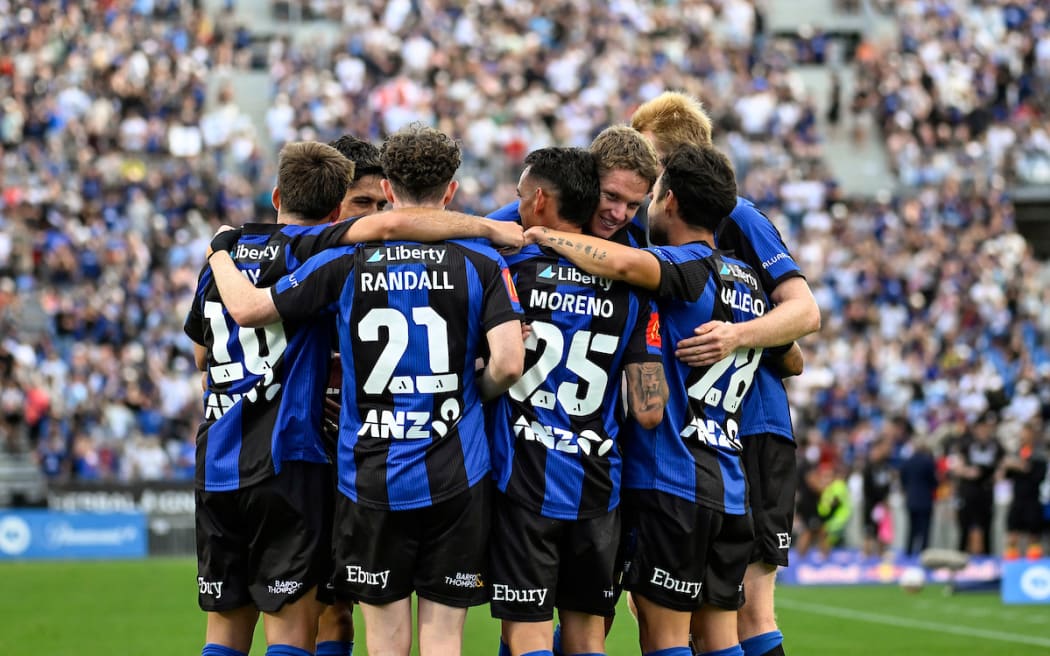 Auckland FC players celebrate a goal against the Wellington Phoenix.