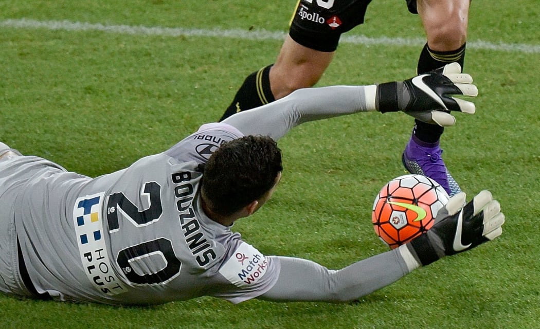 Matthew Ridenton of the Phoenix has a shot at goal blocked by Melbourne FC's keeper Dean Bouzanis.