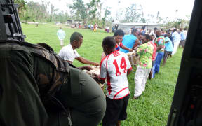Villagers help unload. It is the first aid drop to this Taveuni village.