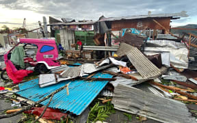 This photo taken on December 17, 2021 shows a resident salvaging belongings among debris caused by Super Typhoon Rai after the storm crossed over Surigao City in Surigao del Norte province.