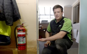 Agriline shareholder James Hamlin indicates the level of water from recent floods at the Gore business.